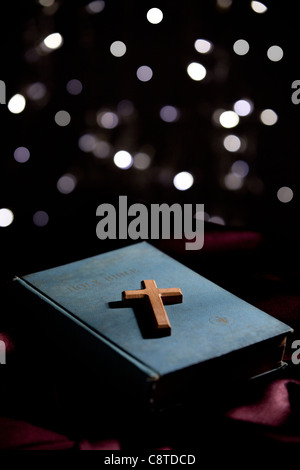 Croix en bois sur la sainte bible avec arrière-plan lumineux Banque D'Images