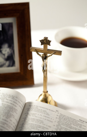 Bible ouverte avec crucifix, cadre photo et le thé noir en arrière-plan Banque D'Images