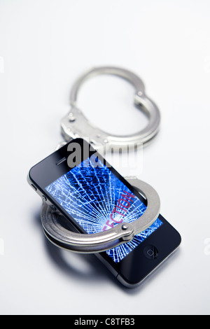 Téléphone mobile avec l'infection et menottes Banque D'Images