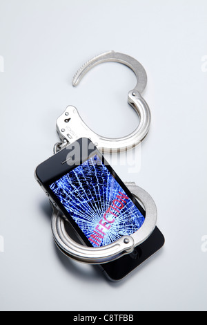 Téléphone mobile avec l'infection et menottes Banque D'Images