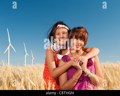 USA, Ohio, Wasco, mère et fille debout dans le champ de blé devant des éoliennes Banque D'Images