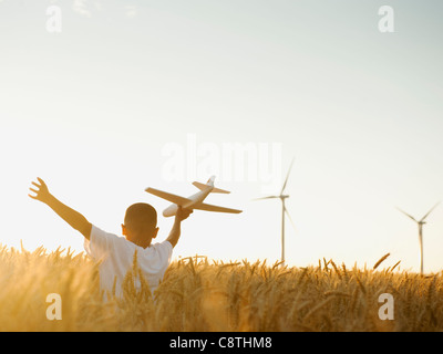 USA, Ohio, Wasco, boy playing with toy airplane in wheat field Banque D'Images