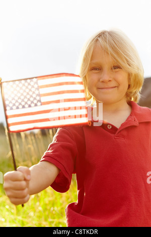USA, Colorado, Boulder, Portrait of boy waving American flag in meadow Banque D'Images