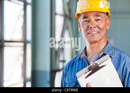 USA, New Mexico, Santa Fe, Portrait of man wearing hardhat holding clipboard Banque D'Images