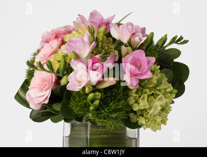 Un gros plan d'un bouquet de fleurs dans un vase. Freesia rose, vert hortensias Banque D'Images