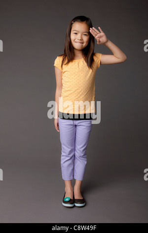 Studio Portrait of Girl saluting Banque D'Images