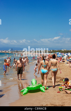 Les gens marchent le long de la plage bondée d'Els Pilons à Salou, Catalogne, Espagne. Banque D'Images