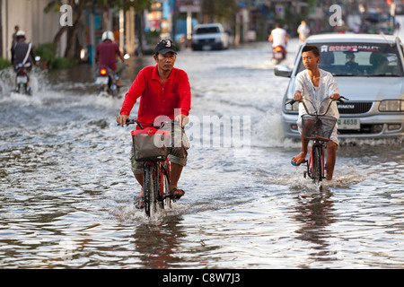 Équitation à travers l'eau d'inondation cycliste en centre-ville de Bangkok, Thaïlande Banque D'Images
