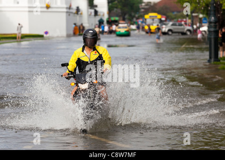 Équitation de moto à travers l'eau d'inondation en centre-ville de Bangkok, Thaïlande Banque D'Images
