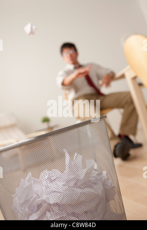 Businessman jetant en boule de papier dans la poubelle Banque D'Images