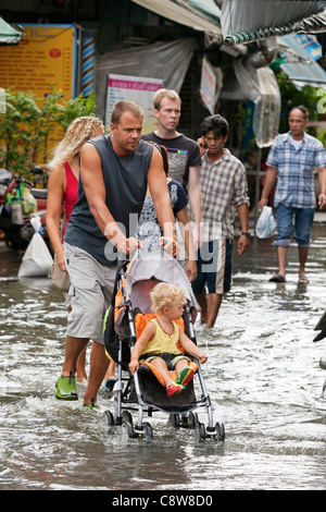 Les touristes en se promenant dans les eaux d'inondation en centre-ville de Bangkok, Thaïlande Banque D'Images