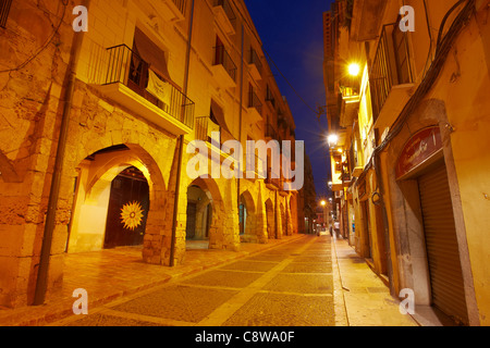 Maisons anciennes sur la rue Merceria (Carrer Merceria) illuminées au crépuscule dans la vieille ville de Tarragone, Catalogne, Espagne. Banque D'Images
