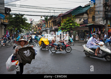 Hanoi street avec les mobylettes et vendeur de rue vendent des T shirts. Vietnam Banque D'Images