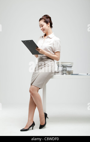 Asian Woman Smiling Holding pavé d'écriture dans la main Banque D'Images