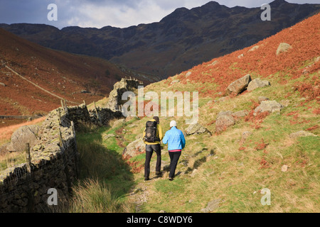 Deux personnes marchant sur Cumbria Way chemin dans Langstrath Valley dans le Parc National de Lake District Cumbria England UK Banque D'Images