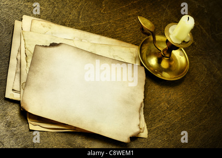 Pages anciennes et bougies sur table en bois Banque D'Images