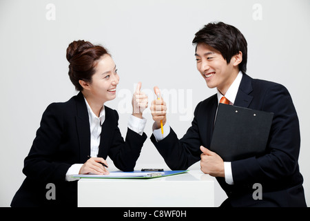 Asian Businessman And Businesswoman Showing Thumb Up signe en 24 en face de l'autre Banque D'Images