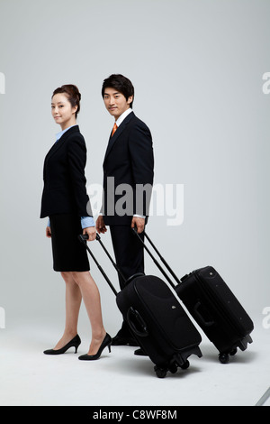 Asian Businesswoman And Businessman With Luggage Banque D'Images