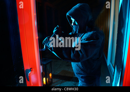 Cambrioleur dans une maison privée. Le cambriolage nocturne. Par effraction dans une chambre pour vos objets en acier. Banque D'Images