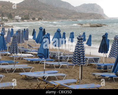 Parasols fermé en cas de tempête sur une plage déserte Banque D'Images