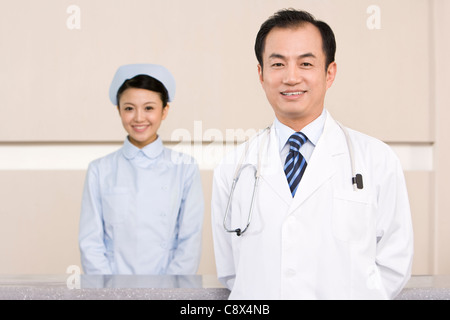 Médecin et infirmière au poste des infirmières Banque D'Images