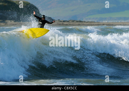 Manèges d'un surfer une vague au large de la plage de Bantham de Devon au cours du mois de novembre. Banque D'Images