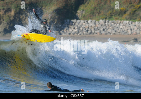 Manèges d'un surfer une vague au large de la plage de Bantham de Devon au cours du mois de novembre. Banque D'Images