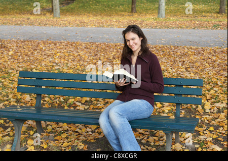 Femme lisant un livre à l'extérieur à l'automne Banque D'Images