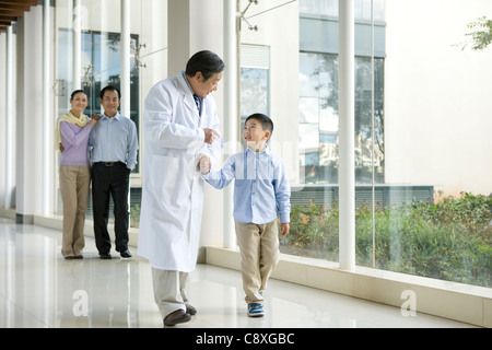 Jeune famille promenades dans un couloir de l'hôpital avec un médecin Banque D'Images