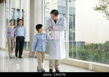 Jeune famille promenades dans un couloir de l'hôpital avec un médecin Banque D'Images