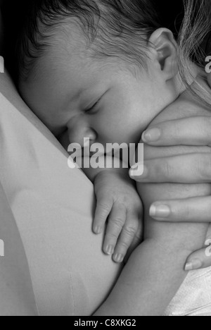 Close up shot noir et blanc d'un bébé nouveau-né garçon être caressé par sa mère Banque D'Images