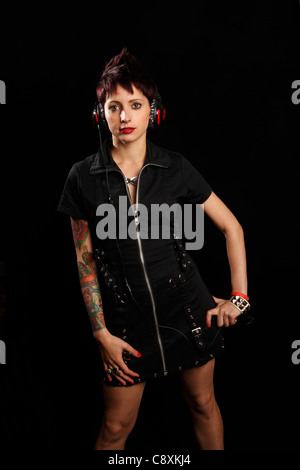 Jeune femme avec des tatouages sur son bras l'écoute de musique au casque Banque D'Images