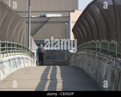 Plus homme marche seul à travers un pont piétonnier à Windsor Terrace, Brooklyn, New York. Banque D'Images