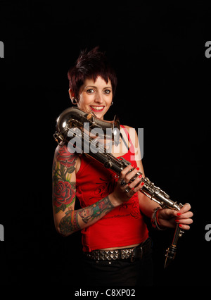 Saxophoniste femelle avec des tatouages sur son bras Banque D'Images