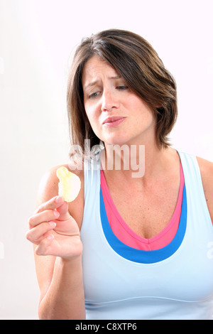 Une jeune femme tenant une pomme de terre tentant Banque D'Images