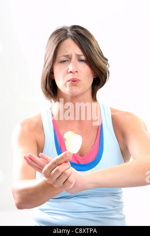 Une jeune femme en bonne santé d'essayer de ne pas manger une croustille focus on hand Banque D'Images