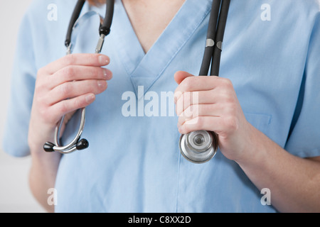 États-unis, Illinois, Metamora, médecin's hands holding stethoscope, mid section Banque D'Images