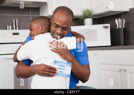 États-unis, Illinois, Metamora, Man holding father's day card et embrassant son (6-7) Banque D'Images