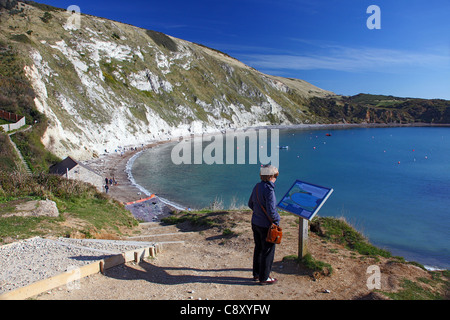 Un visiteur de lire un panneau d'information sur le monde de Lulworth Cove, sur la côte du patrimoine dans le Dorset England UK Banque D'Images