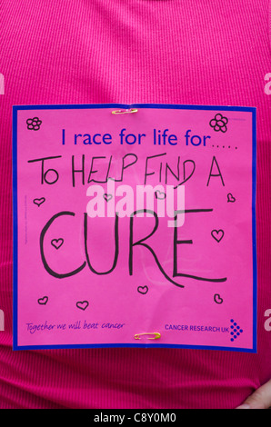 un panneau disant aider à trouver un remède pour le cancer sur la course pour la vie au royaume-uni Banque D'Images
