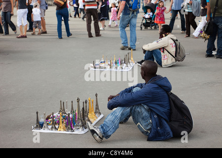 France, Paris, le vendeur de souvenirs africains sous la Tour Eiffel Banque D'Images