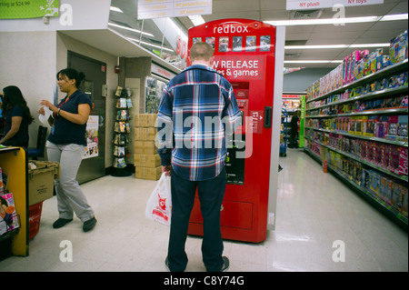 Un client utilise un self-service kiosque de location vidéo Redbox, vu dans un Walgreen's drug store à New York Banque D'Images