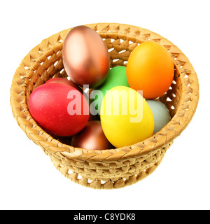 Oeufs de Pâques dans un bol de paille sur l'isolé sur fond blanc Banque D'Images