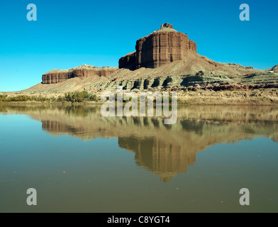 Une butte de grès rouge reflète dans la rivière. Banque D'Images