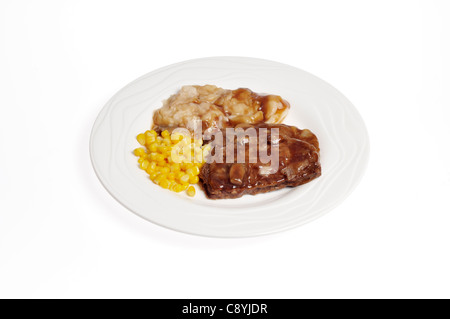 Dîner avec viande sauce oignon, purée de pommes de terre et le maïs sur plaque blanche sur fond blanc. Banque D'Images