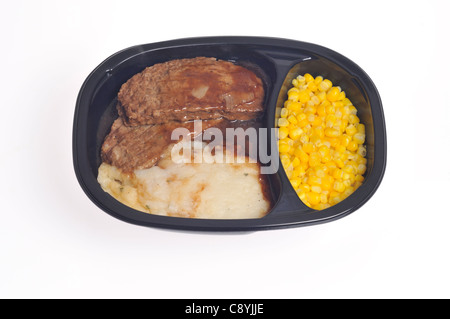 Micro-ondes cuit le pain de viande plat le dîner avec de la sauce, purée de pommes de terre et le maïs doux dans le bac en plastique sur fond blanc. Banque D'Images