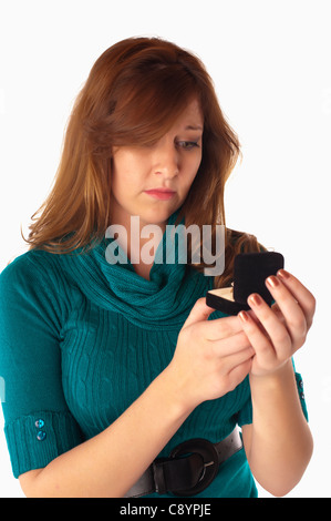 Jeune femme semble être déçu lors de l'ouverture d'une boîte de bague cadeaux Banque D'Images
