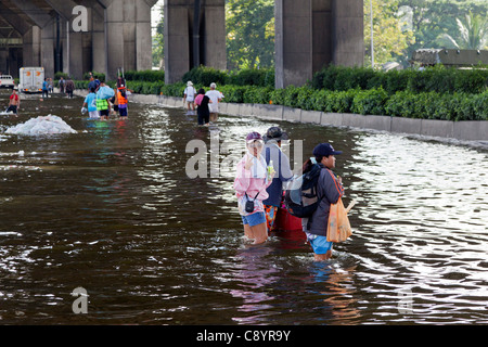 Les gens marcher dans l'eau d'inondation en centre-ville de Bangkok, Thaïlande Banque D'Images