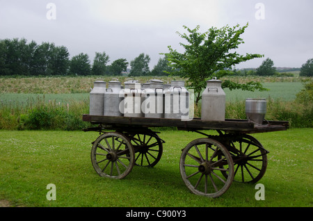 Vieux bidons de lait sur un cheval de bois et panier Banque D'Images