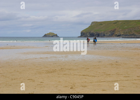 Les surfeurs sur la plage de Polzeath, Cornwall, UK Banque D'Images